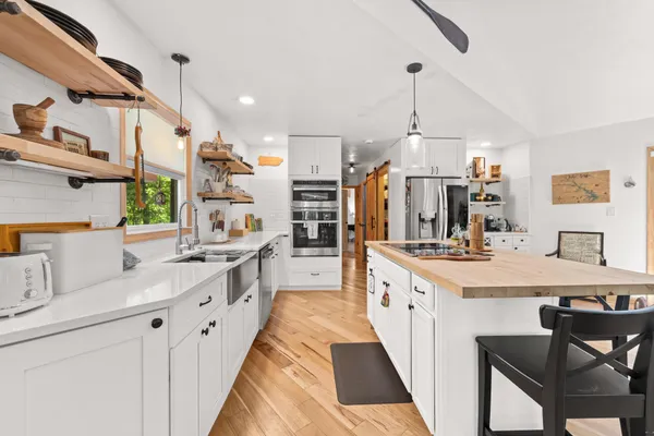 a large kitchen with stainless steel appliances kitchen island granite countertop a sink and cabinets