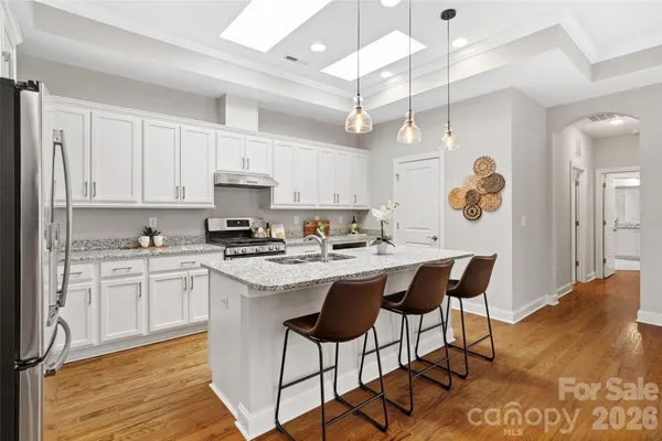 a kitchen with kitchen island granite countertop a sink stove and refrigerator