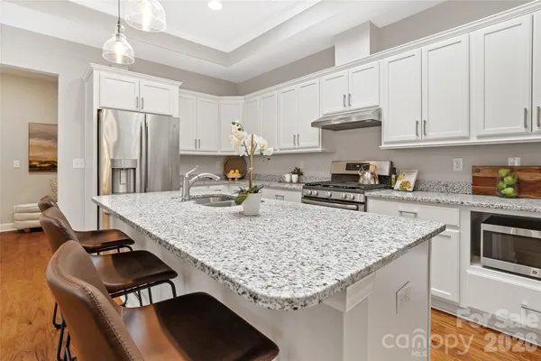 a kitchen with stainless steel appliances granite countertop a lot of counter space and wooden floor