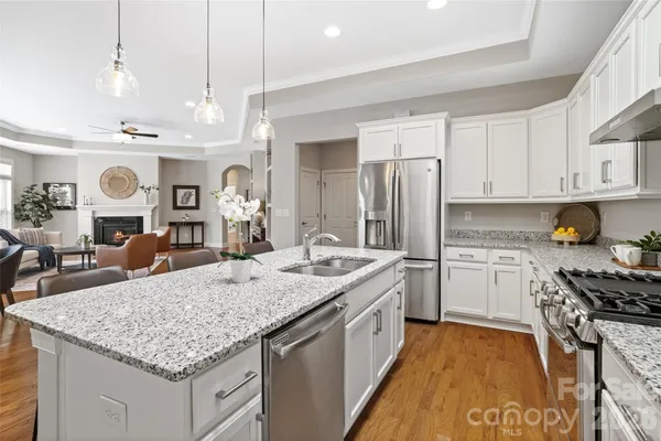 a kitchen with stainless steel appliances granite countertop a sink stove and refrigerator