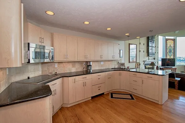 a kitchen with granite countertop white cabinets and white appliances
