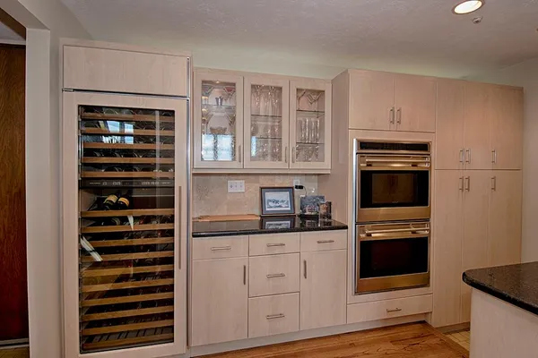 a kitchen with granite countertop a refrigerator and a stove top oven