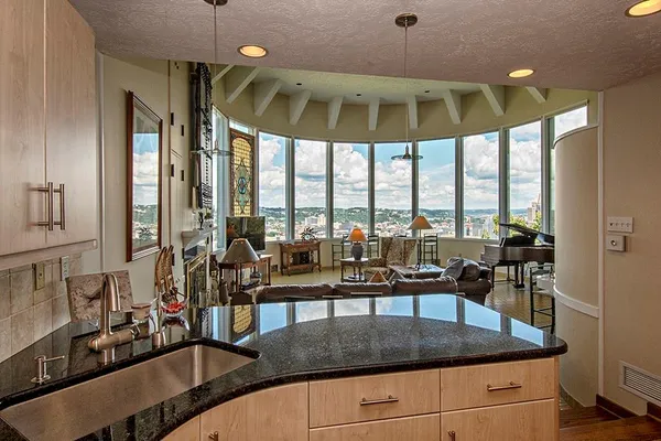 a kitchen with a stove a counter space a large window and furniture