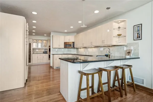 a view of kitchen with stainless steel appliances granite countertop a stove a sink and a refrigerator