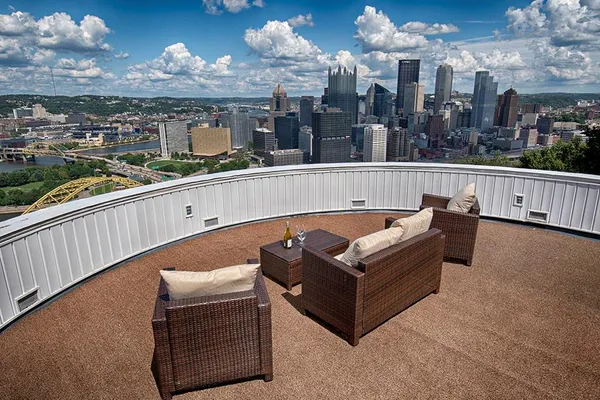 a view of a balcony with wooden floor and outdoor seating