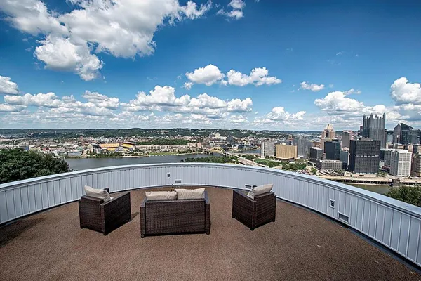 a view of a roof deck with couches and city view