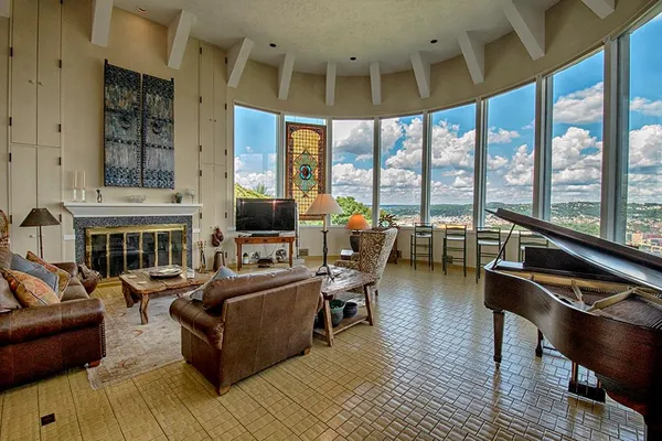 a living room with fireplace furniture and a large window