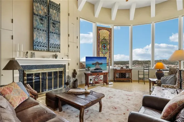 a living room with furniture a fireplace and a large window