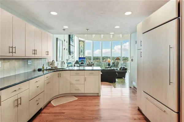a open kitchen with white cabinets and refrigerator