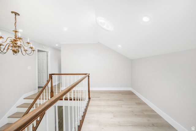 8965 Quail Run Drive Sandy, UT 84093 - Photo 20 of 56 Hallway featuring light wood-type flooring, vaulted ceiling, an upstairs landing, and hanging lights