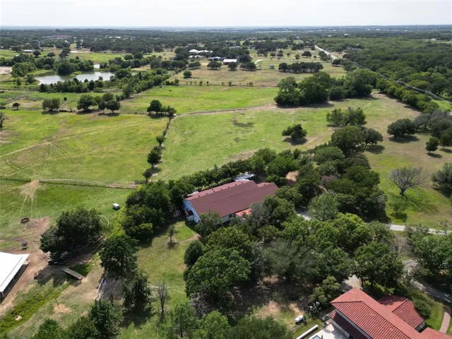 an aerial view of residential houses with outdoor space and trees