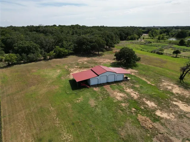 an aerial view of residential houses with outdoor space and trees