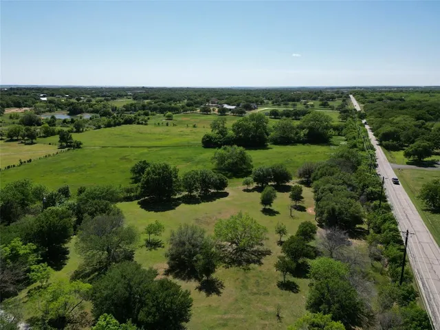 an aerial view of residential houses with outdoor space and trees