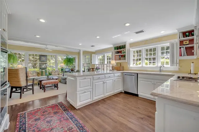 a kitchen with a sink wooden floor dining table and chairs