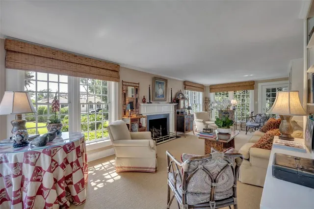 a living room with furniture a fireplace and a large window with garden view