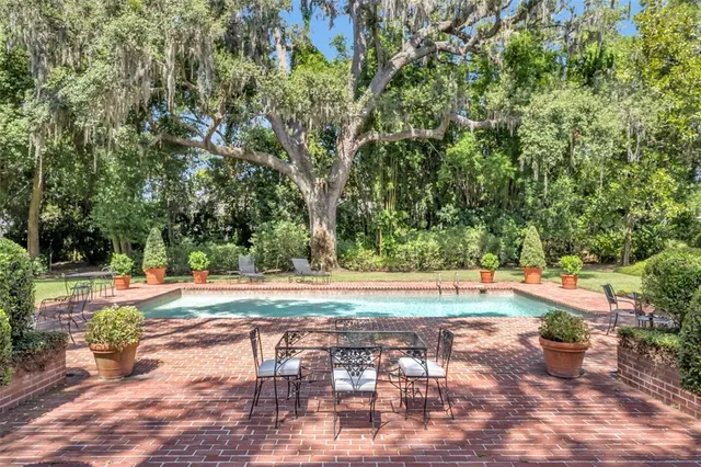 a view of swimming pool with outdoor seating and plants