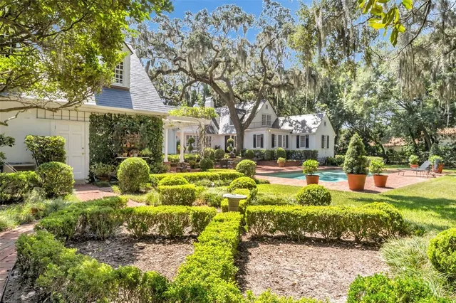 a view of a white house with a yard and plants