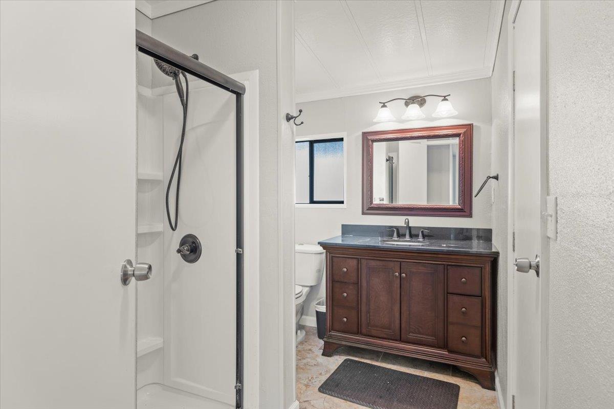 4420 Pleasant Valley Road, Unit 184 Diamond Springs, CA 95619 - Photo 19 of 28 a bathroom with a granite countertop sink vanity and mirror