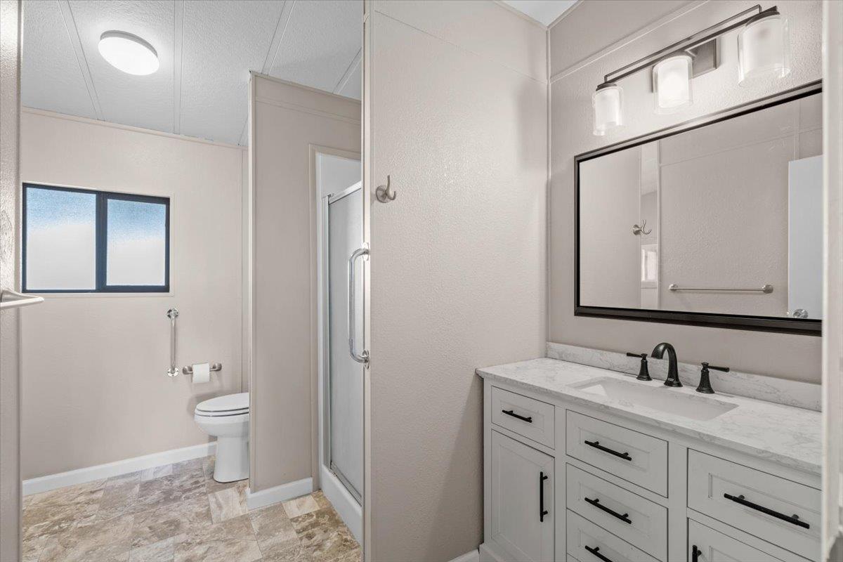 4420 Pleasant Valley Road, Unit 184 Diamond Springs, CA 95619 - Photo 22 of 28 a bathroom with a toilet a sink a vanity and mirror