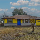 a view of a house with a backyard and a tree