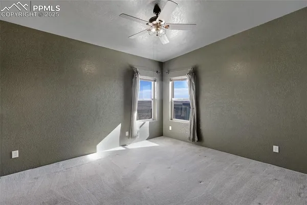 en empty room with windows and fan