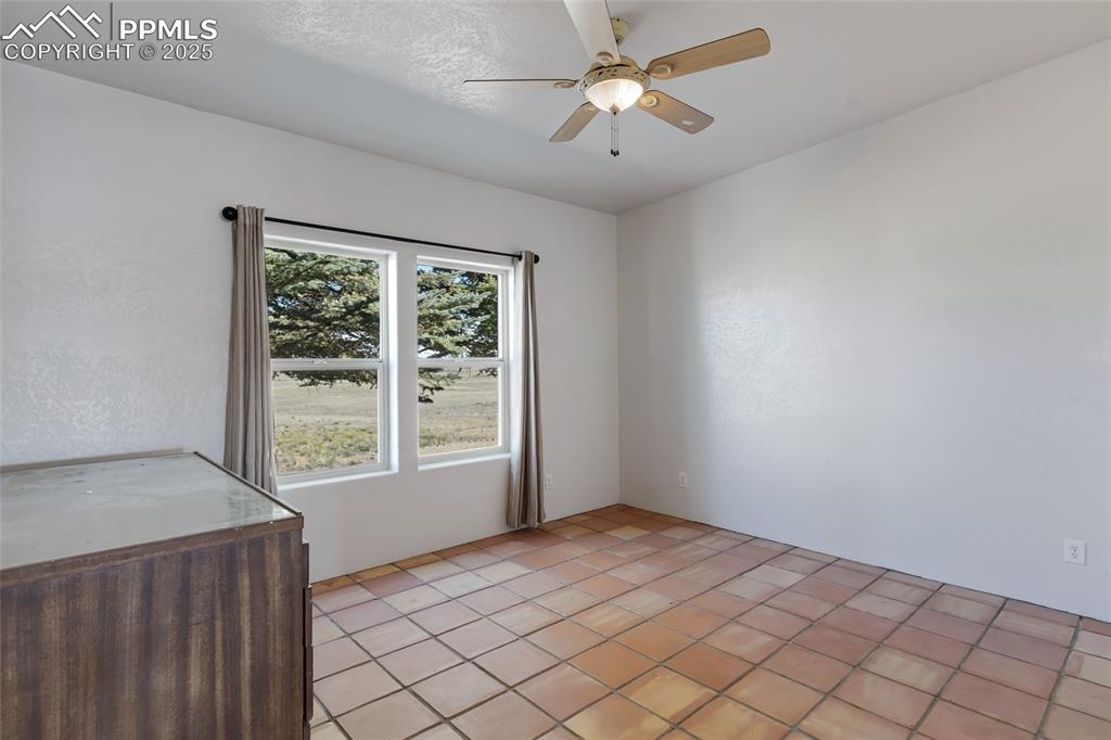 18450 Eurich Road Calhan, CO 80808 - Photo 26 of 48 an empty room with chandelier fan and window