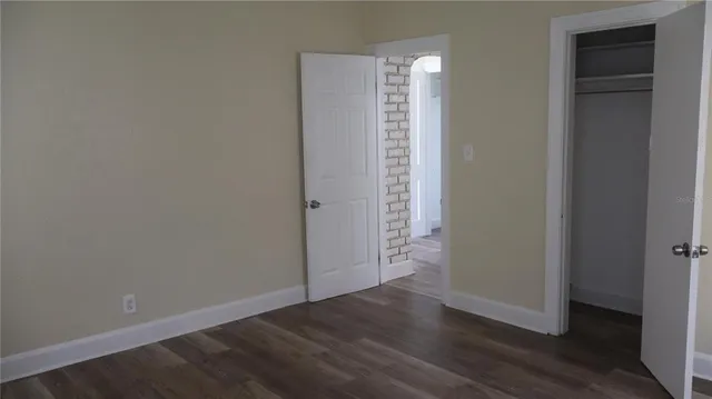 an empty room with wooden floor and closet