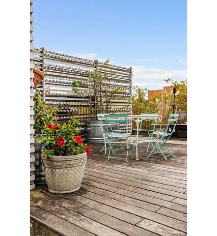 a view of a balcony with chairs and potted plants