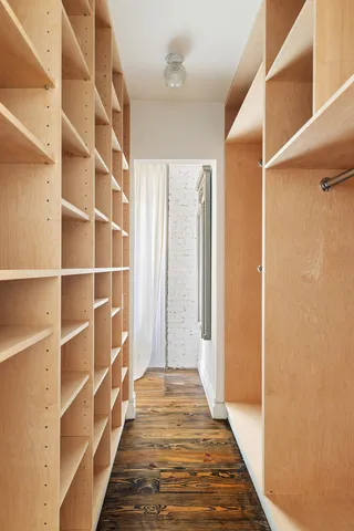 a view of a hallway with wooden floor and a window