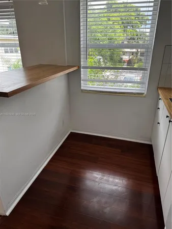 a view of a small space with wooden floor and a window