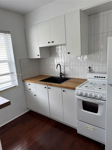a kitchen with a stove and white cabinets