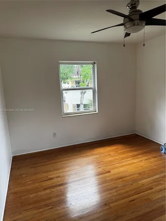 a view of a room with wooden floor and a window