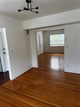 a view of a big room with wooden floor and windows