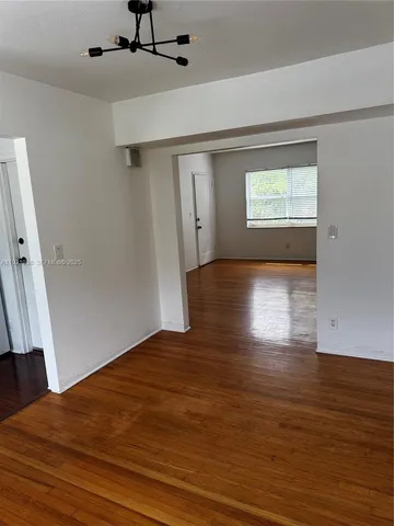 a view of a big room with wooden floor and windows