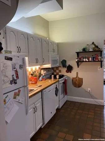 a kitchen with white cabinets and white appliances