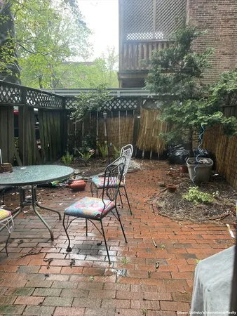 a view of backyard with table and chairs and wooden fence