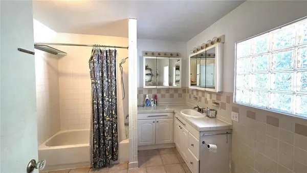 a bathroom with a tub sink and mirror