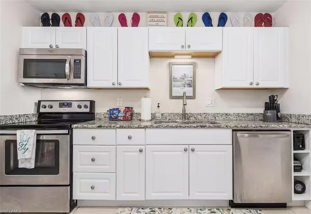 3024 Estey Avenue Naples, FL 34104 - Photo 7 of 19 a kitchen with stainless steel appliances granite countertop a stove and a microwave