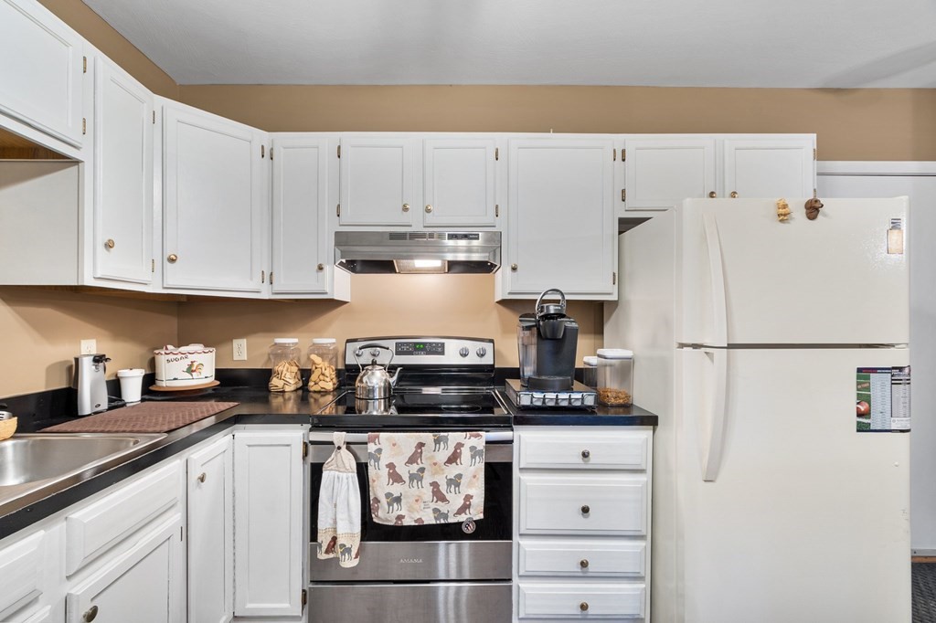 5 Tsienneto Road, Unit 198 Derry, NH 03038 - Photo 6 of 21 a kitchen with white cabinets and white appliances