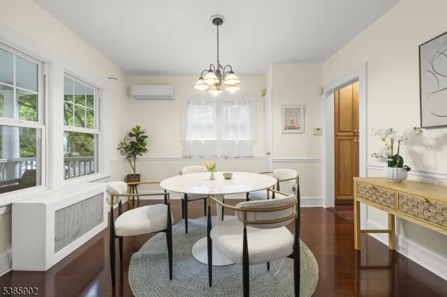 a dining room with furniture a chandelier and wooden floor