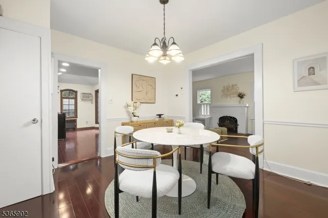 a view of a dining room with furniture a chandelier and wooden floor