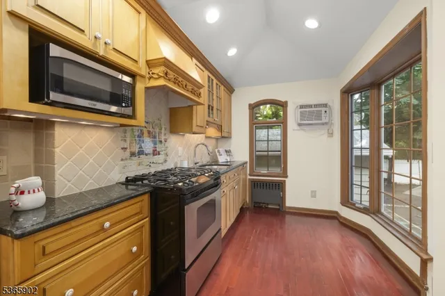a kitchen with stainless steel appliances granite countertop a stove a sink and a microwave