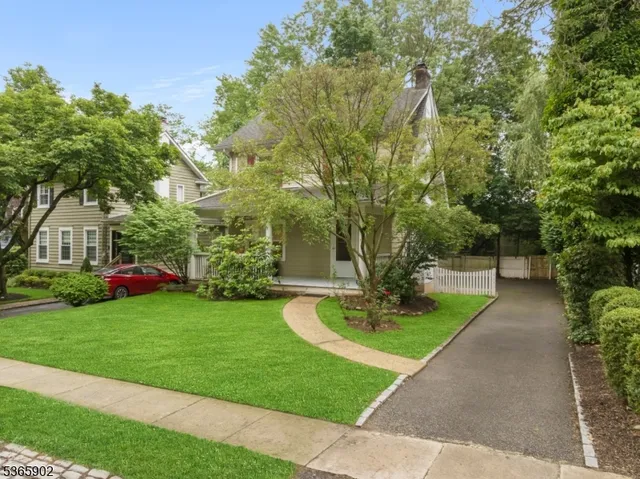 an aerial view of a house with outdoor space and trees all around