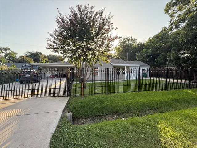 a view of house with a big yard and potted plants
