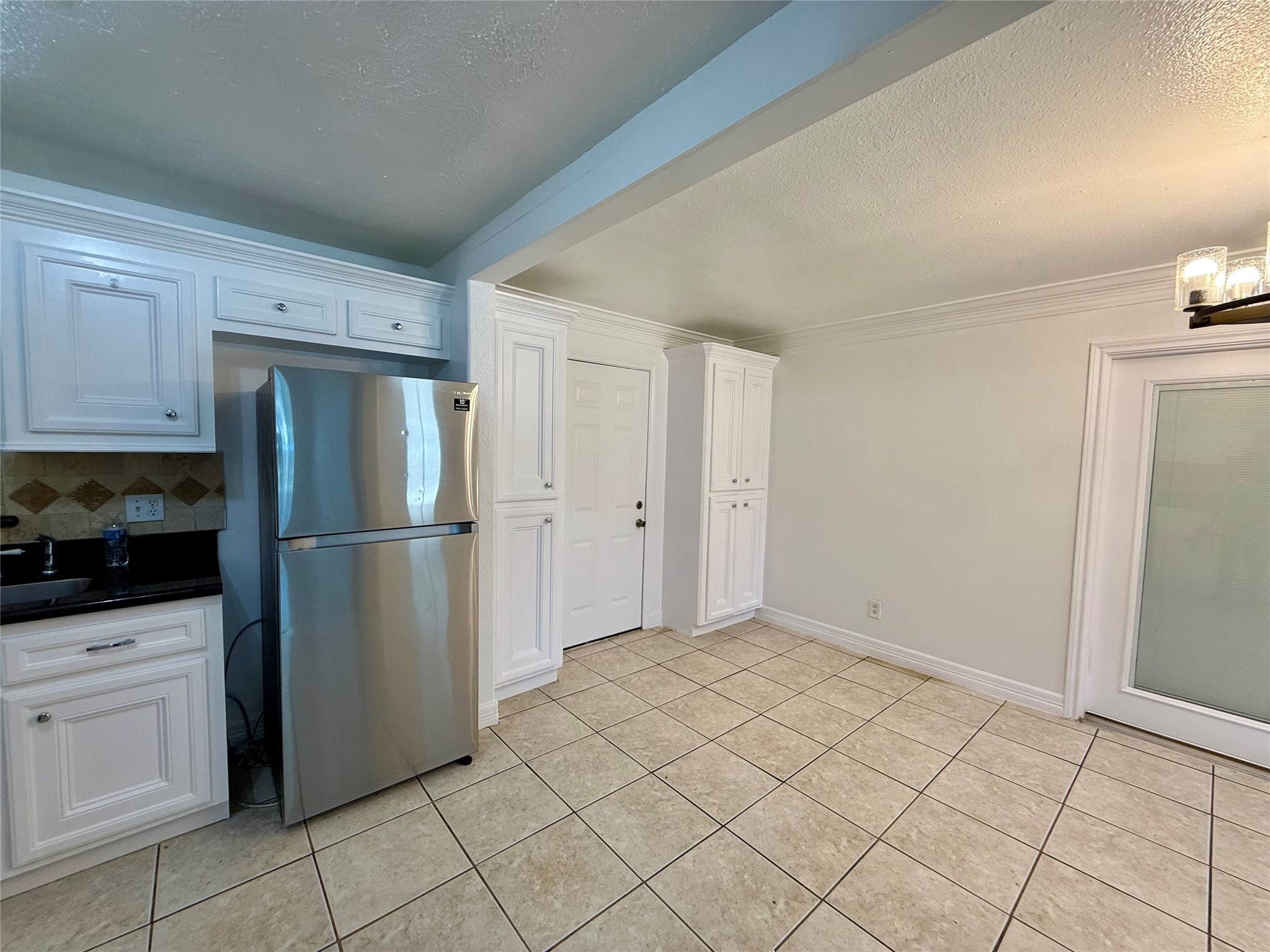 5701 Luna Street Houston, TX 77076 - Photo 24 of 50 a kitchen with white cabinets a refrigerator and white cabinets