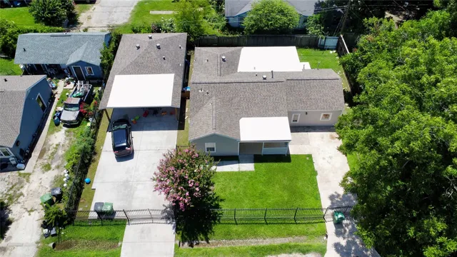 an aerial view of residential houses with outdoor space and trees