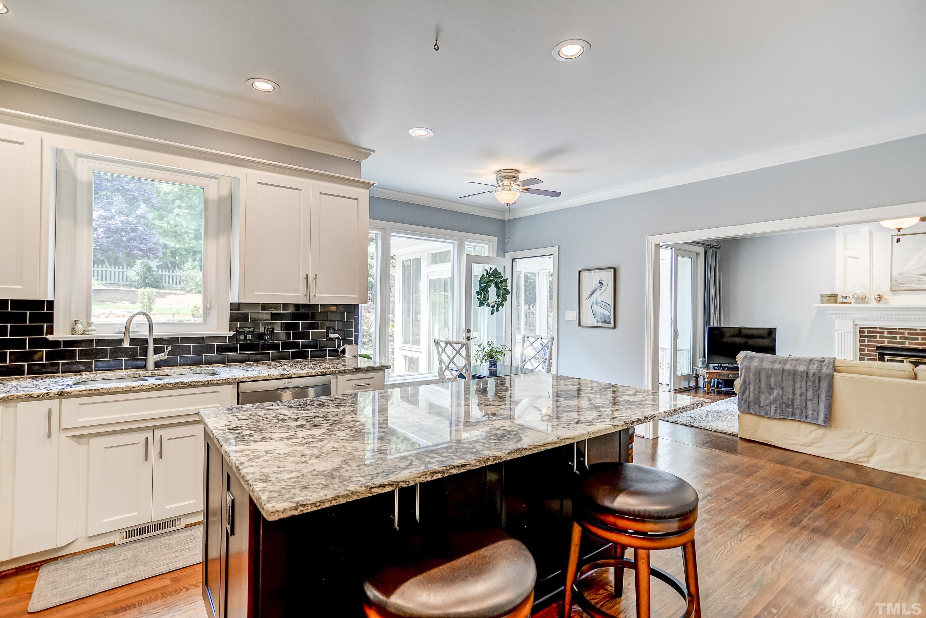 1309 Wescott Drive Raleigh, NC 27614 - Photo 13 of 32 a kitchen with a stove a sink dishwasher a dining table and chairs with wooden floor