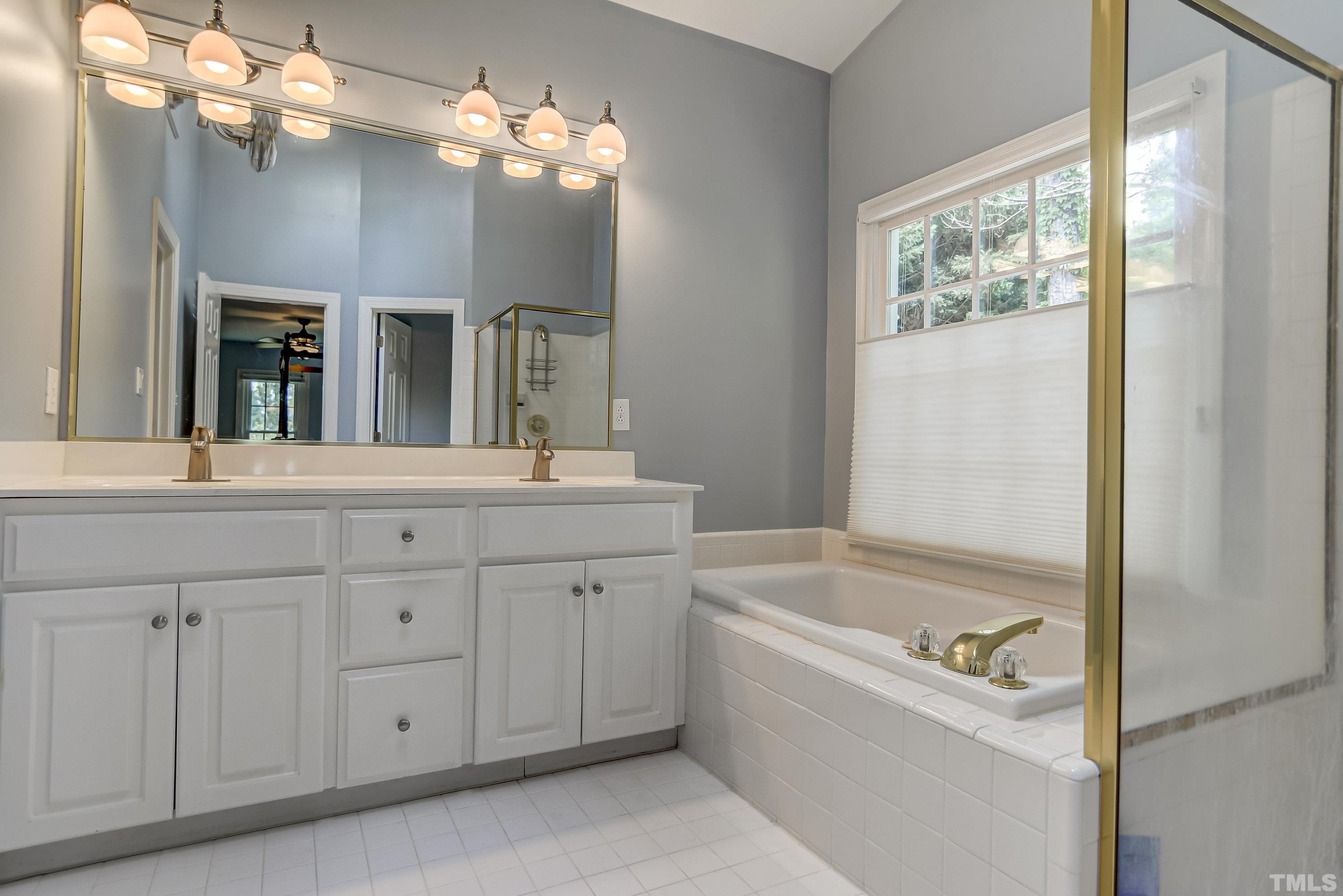 1309 Wescott Drive Raleigh, NC 27614 - Photo 19 of 32 a bathroom with a tub a sink and a large mirror