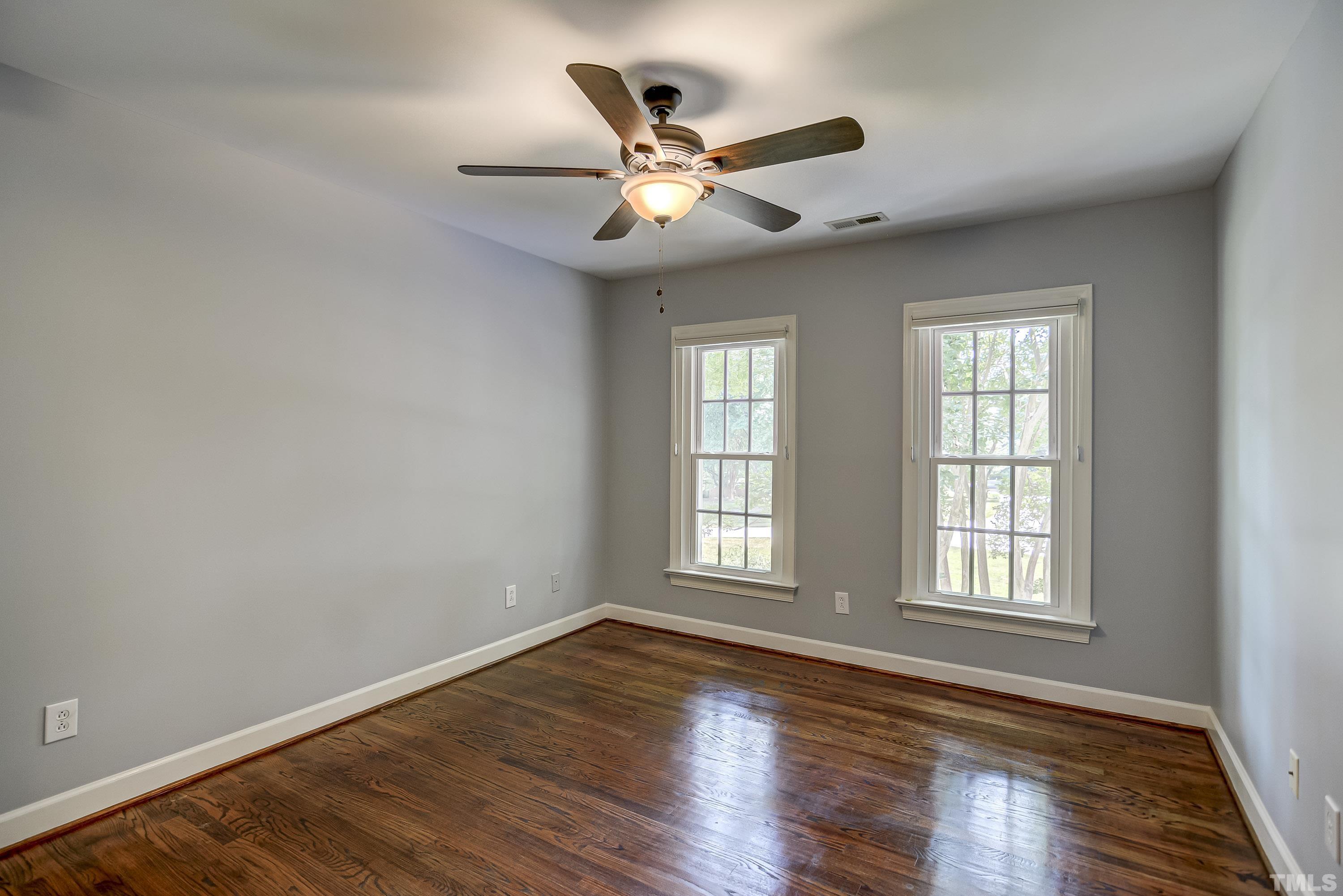 1309 Wescott Drive Raleigh, NC 27614 - Photo 20 of 32 an empty room with wooden floor fan and windows