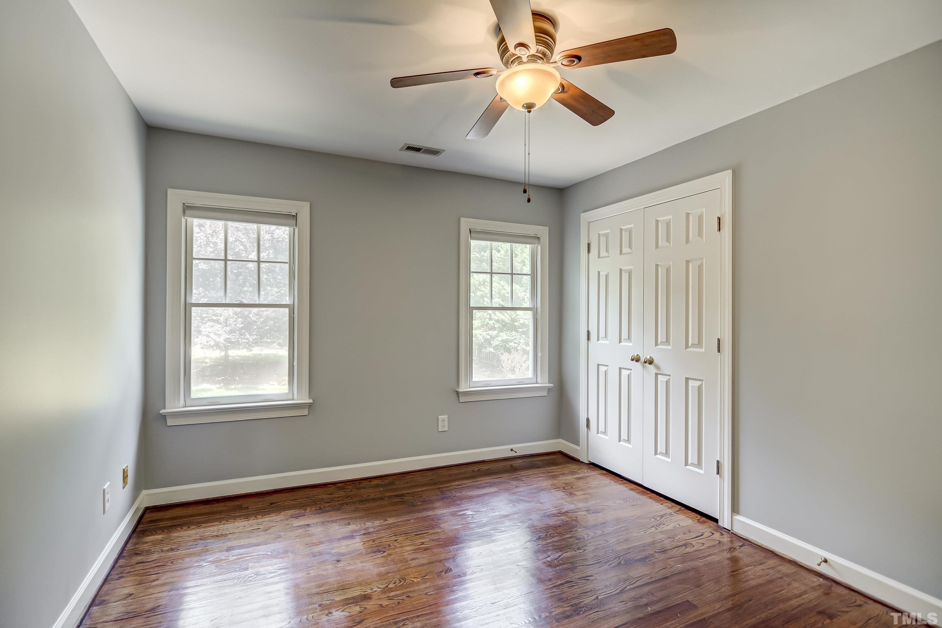1309 Wescott Drive Raleigh, NC 27614 - Photo 21 of 32 an empty room with wooden floor ceiling fan and windows